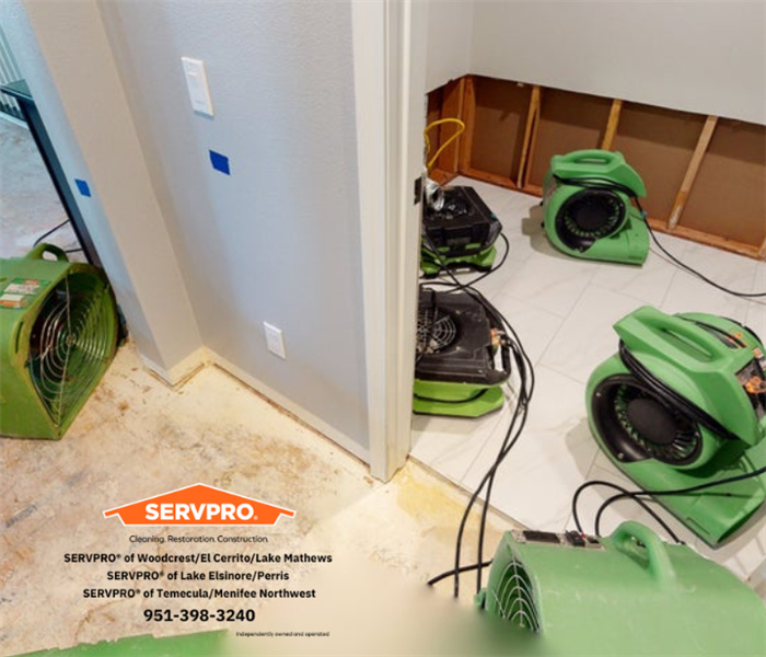 Many air movers in a laundry room and hallway into a family room dying all the demo floors and walls.